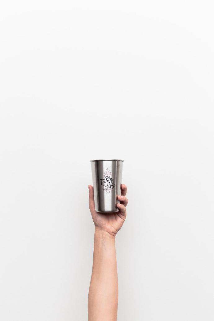 person holding gray stainless steel drinking cup